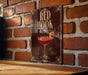 A poster with the text "RED HOOK" and an illustration of a cocktail on a wooden surface against a brick wall.