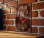 A poster or sign for "Reposado Manhattan" is displayed on a brick wall, featuring an illustration of a cocktail glass with a cherry.