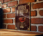 A sign with the text "Reverse Manhattan" and an illustration of a martini glass with a cherry on top, mounted on a brick wall.