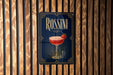A poster for "ROSSINI" cocktail, featuring a glass of red cocktail with a strawberry garnish, against a wooden background.