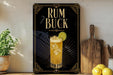 a decorative sign with the text "RUM BUCK" and an illustration of a rum and lime drink.