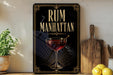 a decorative sign with the text "RUM MANHATTAN" and an illustration of a glass of rum with a straw.