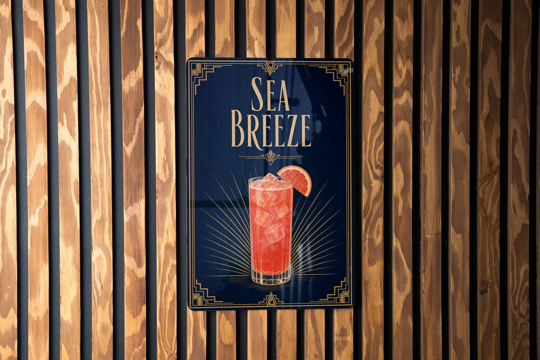 A sign for a Sea Breeze cocktail is displayed on a wooden wall.