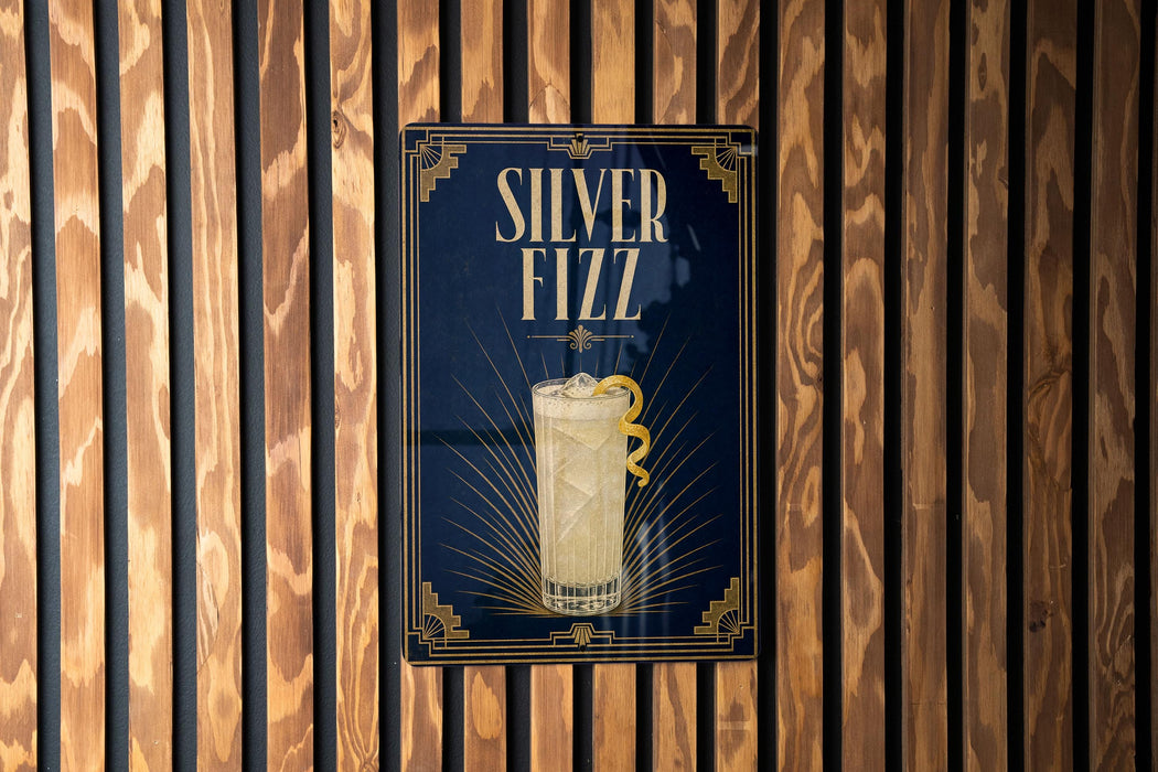 A poster for "Silver Fizz" cocktail, featuring a glass illustration and the text "Silver Fizz" prominently displayed.