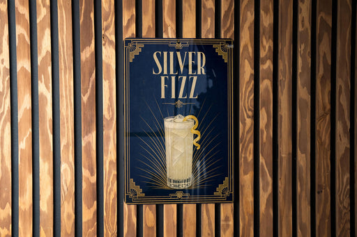 A poster for "Silver Fizz" cocktail, featuring a glass illustration and the text "Silver Fizz" prominently displayed.