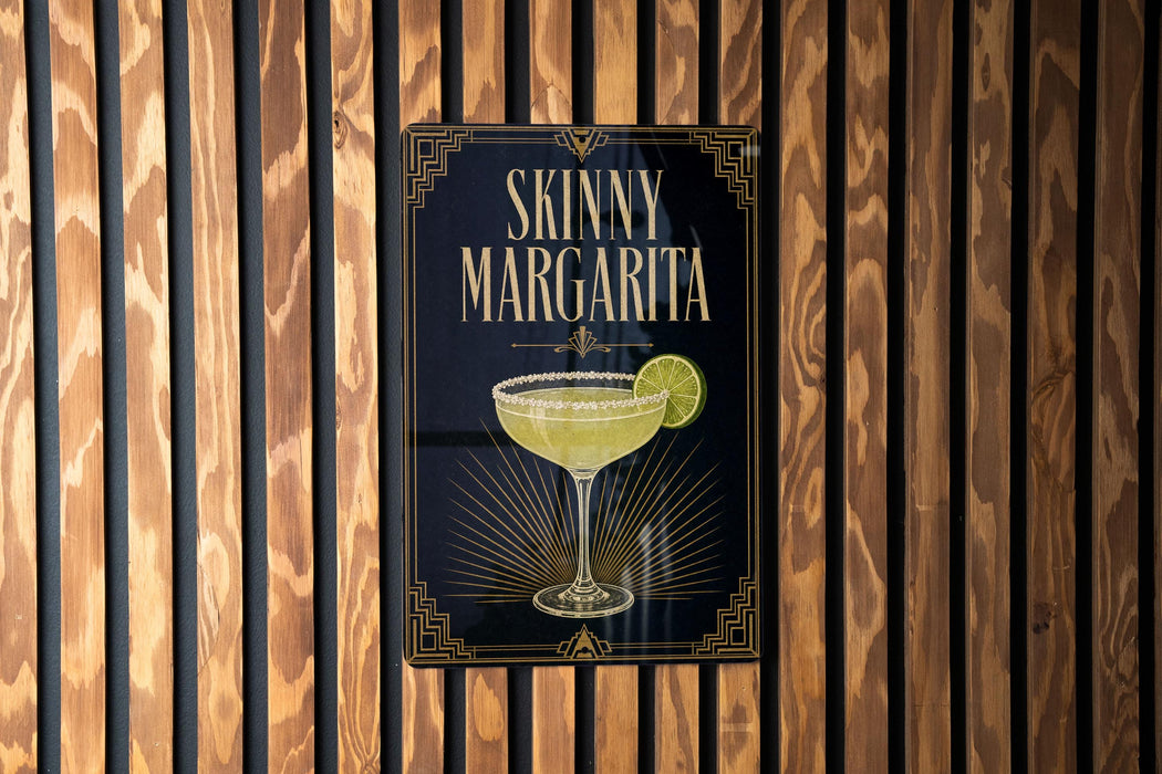 A sign for a "Skinny Margarita" cocktail is displayed on a wooden wall.