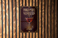 A poster for "Smoked Maple Manhattan" cocktail is displayed on a wooden wall.