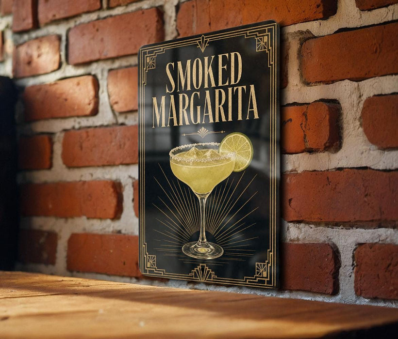A framed poster of a margarita glass with the text "SMOKED MARGARITA" is displayed on a brick wall.