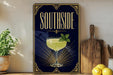 A framed poster with the text "SOUTHSIDE" and an illustration of a cocktail glass with a mint leaf garnish.