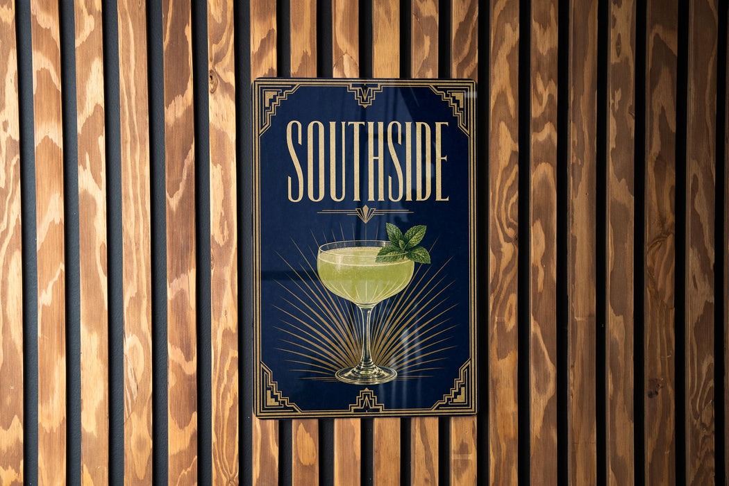 A poster with the word "SOUTHSIDE" and an illustration of a cocktail is displayed on a wooden wall.