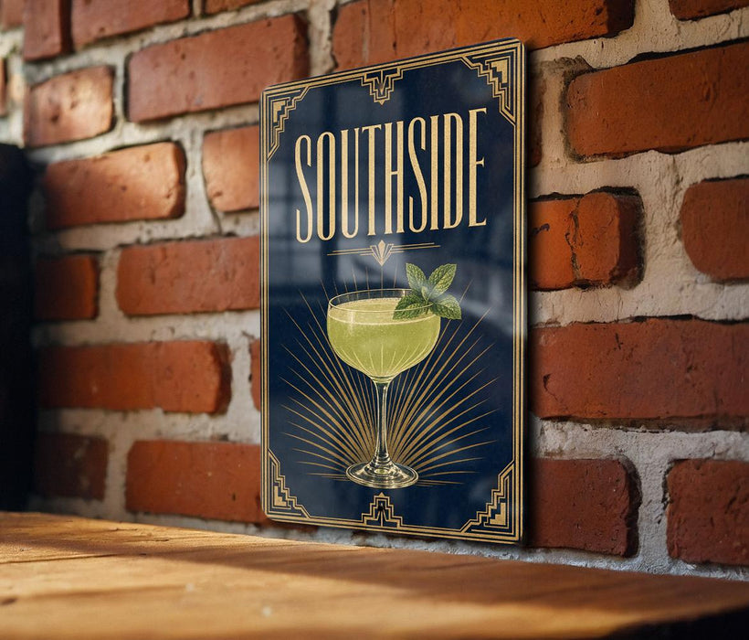 A poster with the word "SOUTHSIDE" and an illustration of a cocktail glass with a mint leaf on a brick wall.