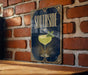 A poster with the word "SOUTHSIDE" and an illustration of a cocktail glass with a mint leaf on a brick wall.