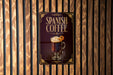 A sign for Spanish coffee is displayed on a wooden wall.