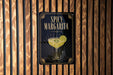 A sign for a spicy margarita cocktail is displayed on a wooden wall.