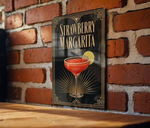 A framed poster of a strawberry margarita is displayed on a brick wall.