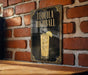 A sign for "Tequila Highball" is displayed on a brick wall, featuring an illustration of a tequila highball cocktail with a lime slice.
