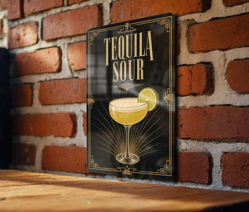 A sign with the text "TEQUILA SOUR" and an illustration of a tequila sour cocktail on a brick wall.
