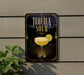 A sign for "Tequila Sour" is displayed on a wall, featuring an illustration of a tequila sour cocktail with a lime slice.