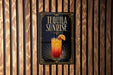 A sign for "Tequila Sunrise" is displayed on a wooden wall.