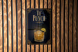 A sign for "Tri Punch" is displayed on a wooden wall, featuring an illustration of a cocktail glass with a lime slice.