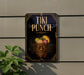 A sign for "Tiki Punch" is displayed on a wall, featuring a tiki mask and a tiki drink.