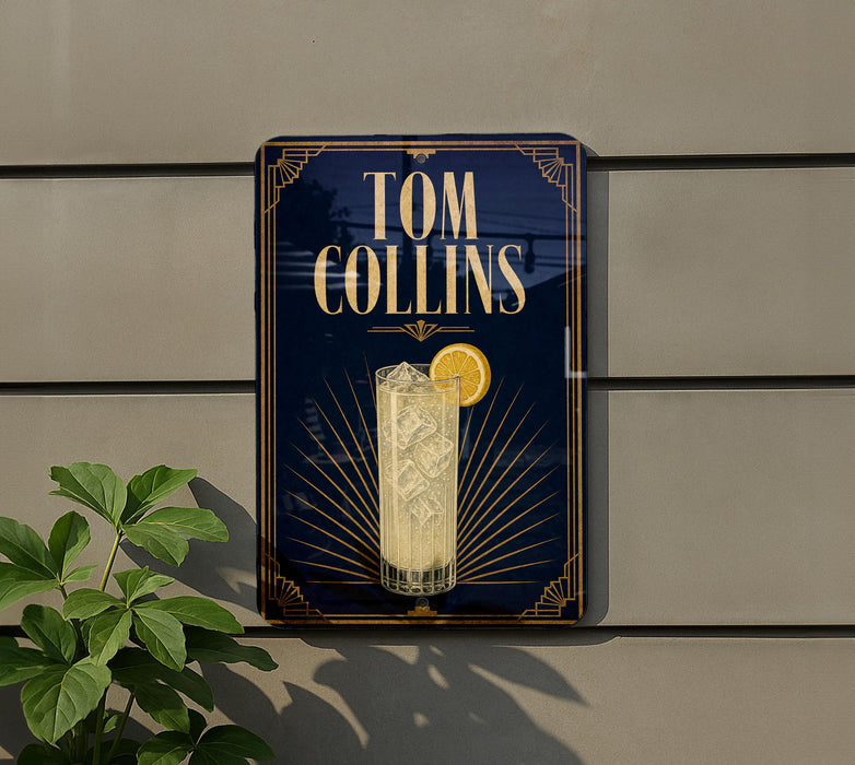 A sign for a cocktail named "Tom Collins" is displayed on a wall, featuring an illustration of a cocktail glass with a lemon slice.