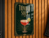 A sign for "Trinidad Sour" cocktail, featuring a glass illustration and a lemon slice.
