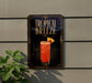 A sign for a tropical breeze drink is displayed on a wall, featuring an illustration of a tall glass filled with a red beverage and a pineapple slice.