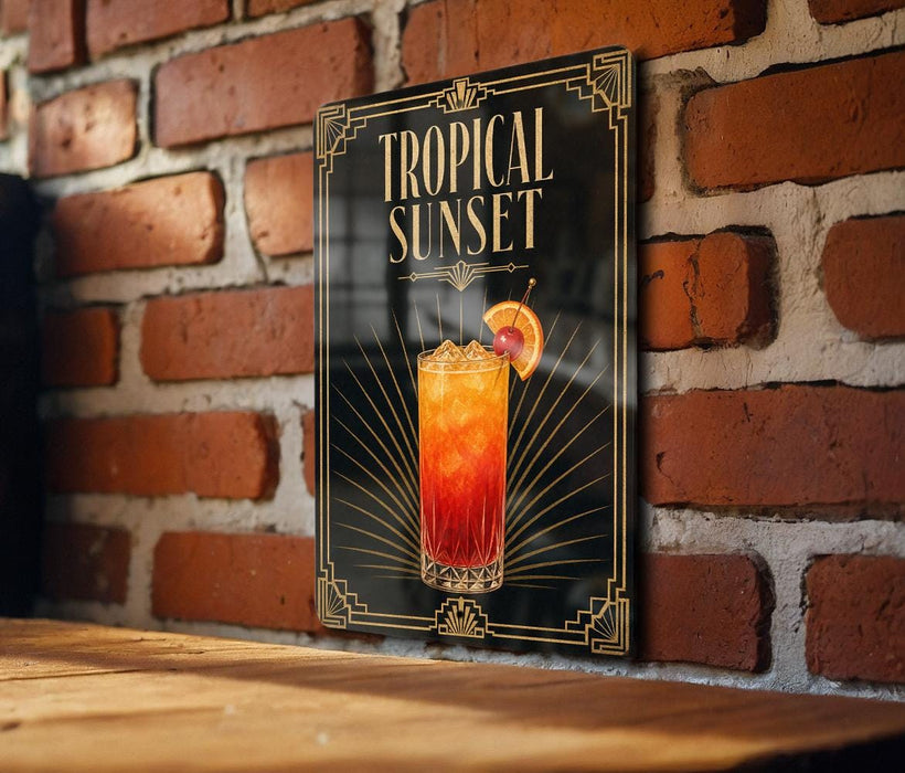 A framed poster of a tropical sunset cocktail is displayed on a brick wall.