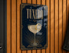 A framed poster or sign with the word "Tuxedo" prominently displayed, featuring an illustration of a martini glass with a lemon twist.