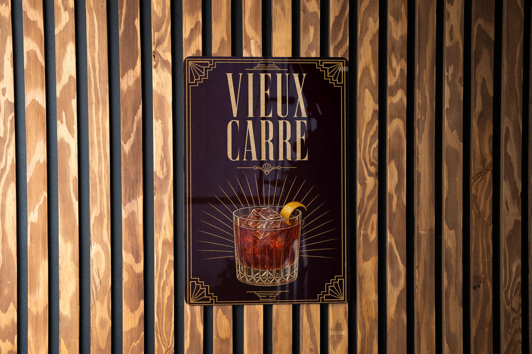 a poster with a glass of amber-colored liquid and a lemon slice, displayed on a wooden wall.