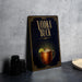 A black and gold advertisement for vodka called "Vodka Buck" featuring an illustration of a copper mug with a drink inside.