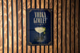 A sign for vodka gimlet is displayed on a wooden wall.