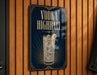 A sign with the text "VODKA HIGHBALL" and an illustration of a cocktail glass with ice cubes and a lemon slice.