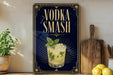 a framed advertisement for a vodka smash cocktail, with a glass of the cocktail and a mint garnish displayed on the poster.