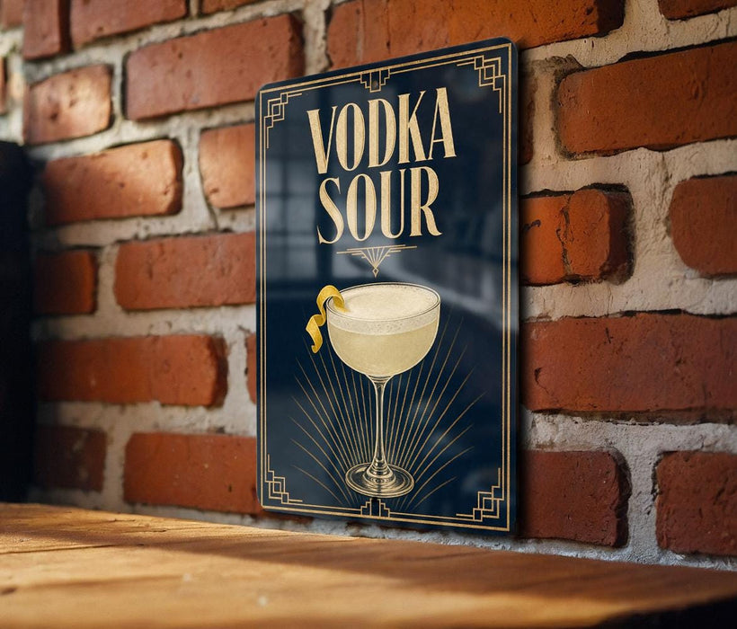 A sign with the text "VODKA SOUR" and an illustration of a cocktail glass with a lemon twist, mounted on a brick wall.