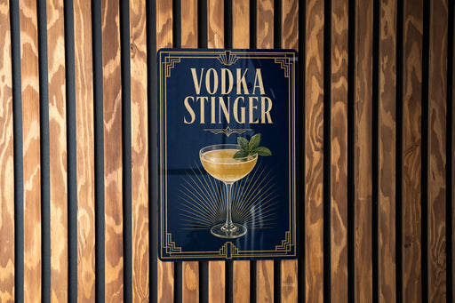A sign for a vodka cocktail called "Vodka Stinger" is displayed on a wooden wall.