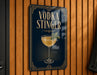 A sign for a vodka drink called "Vodka Stinger" is displayed on a wooden wall.