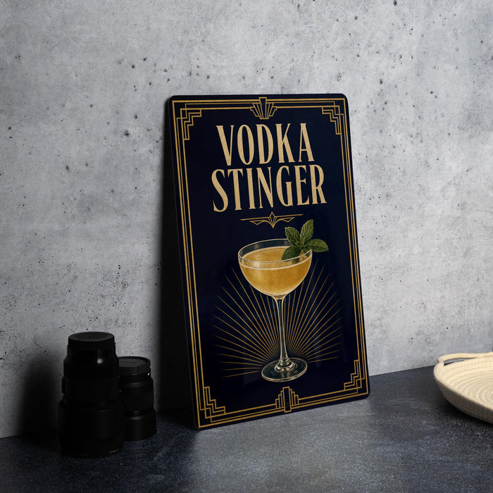 a decorative sign with the text "VODKA STINGER" and an illustration of a cocktail glass with a mint garnish.