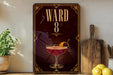 A decorative sign with the number "8" and a cocktail image, placed on a wooden surface next to a wooden cutting board and a potted plant.
