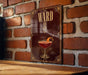A sign with the number "8" and an illustration of a cocktail on a wooden surface against a brick wall.