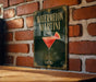 A sign for a "Watermelon Martini" is displayed on a brick wall, featuring a glass of the cocktail with a slice of watermelon.