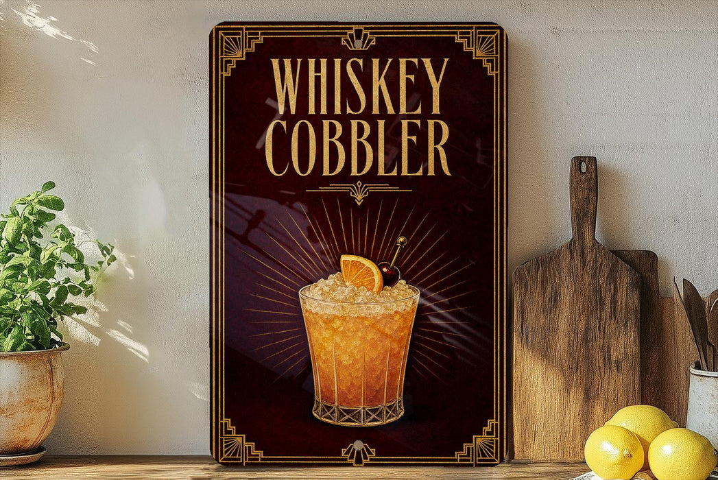 A framed advertisement for a whiskey cobbler cocktail, featuring an illustration of a glass filled with the cocktail and garnished with an orange slice.