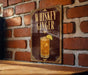 A sign with the text "WHISKEY GINGER" and an illustration of a cocktail is displayed on a brick wall.