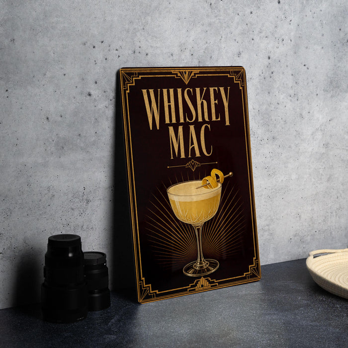 A decorative sign for a whiskey mac cocktail, featuring an illustration of a cocktail glass with a lemon twist.