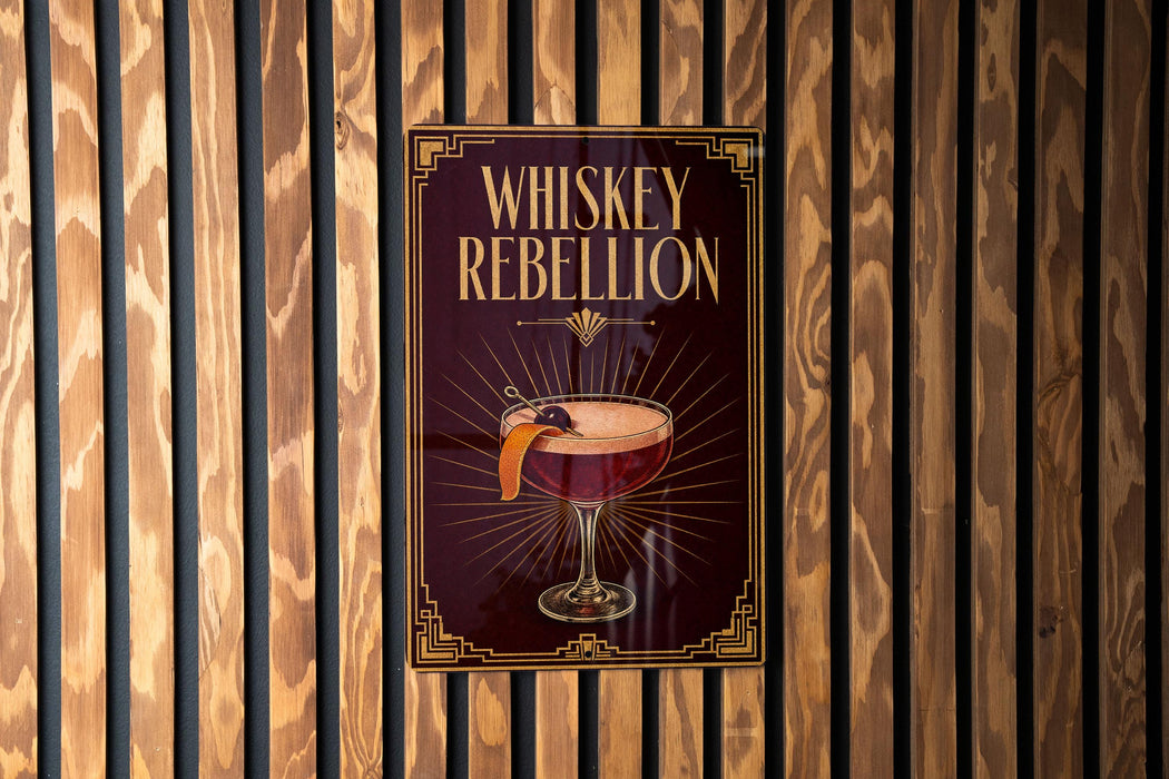A poster with the title "Whiskey Rebellion" displayed on a wooden wall.
