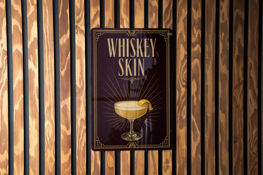 A sign with the text "Whiskey Skin" and an illustration of a cocktail glass with a lemon slice.