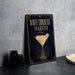 A black and gold sign with the text "WHITE CHOCOLATE MARTINI" and an illustration of a martini glass with a chocolate garnish.
