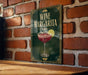 A sign for a wine margarita is displayed on a brick wall, featuring an illustration of a wine glass with a slice of lime.