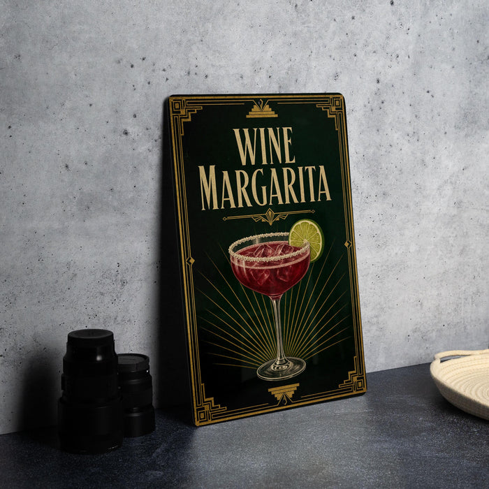 A framed image of a wine margarita on a wall, with a stack of black cups and a white dish nearby.